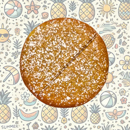 Power cookie pineapple with powdered sugar on a summer-themed background with pineapples, flowers, and suns.