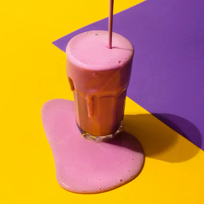 Glass of strawberry flavored vegan protein powder from planet amino
